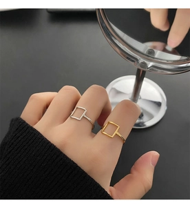 Detailed view of minimalist square hollow rings in polished gold and silver finishes