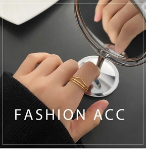 Detail view of a three-tier gold titanium ring with a V-shape geometric design on a finger