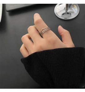 Detail of silver titanium steel stacked ring with geometric V-shape design on model finger