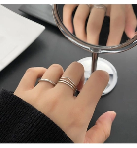 Detail of silver minimalist stackable rings featuring a V-shaped geometric layered design