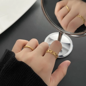 Two-piece gold titanium steel ring set featuring a plain band and hollow heart design