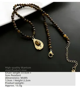 Détail macro du collier en perles d'œil de tigre avec pendentif goutte dorée et fermoir