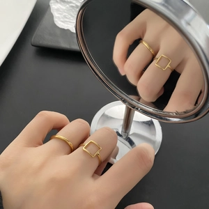 Minimalist 18K gold plated square geometric ring set on reflective mirror surface