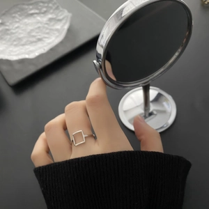 Minimalist square geometric hollow ring in polished silver finish worn on finger