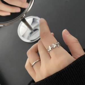 Set of two silver butterfly hollow rings and minimalist band shown on a hand with reflection