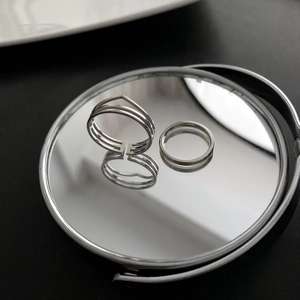 Two-piece silver geometric titanium steel rings set on mirror with black background