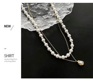 Macro detail of double-layer faux pearl and gold titanium steel necklace with charm