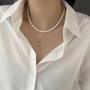 Double-layer pearl necklace set featuring a choker and a gold chain with oval pendant