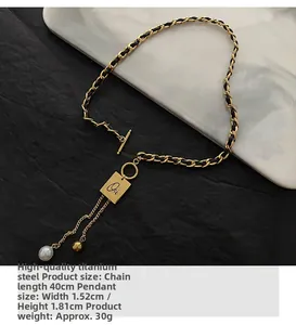 Detail of gold titanium steel woven leather chain necklace with Oui pendant and pearl tassel