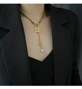 Detail of woven leather necklace with square Oi pendant and elegant pearl tassel