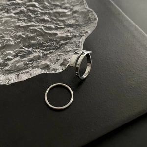 Macro shot of silver titanium steel rings with polished finish on a textured black base