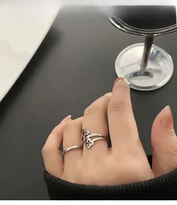 Macro detail of silver four-leaf clover and butterfly rings on fingers in vintage style