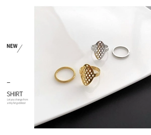 Detail of 18k gold plated hollow geometric and minimalist stacking rings set on ceramic