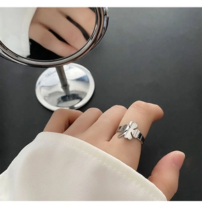 Detailed close-up of a silver four-leaf clover ring with high-polish mirror finish
