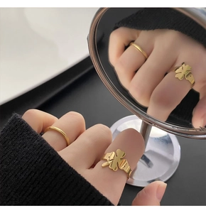Close-up of golden four-leaf clover ring set with reflective mirror creative display