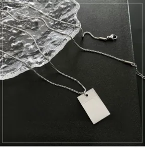 Detailed close-up of a silver rectangular titanium steel pendant with engraved cloud patterns
