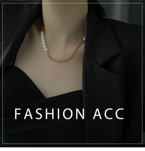 Detail of gold curb chain and white pearl necklace on a professional black suit