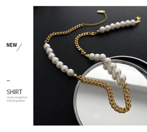 Detail of gold chunky chain and imitation pearl necklace on a mirror background