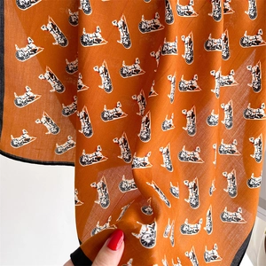 Detail of orange square scarf with horse carriage print and fine twill texture fabric