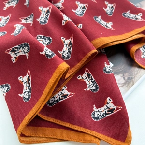 Detailed macro view of burgundy silk scarf showing herringbone texture and dog illustration