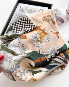 Detail of floral silk scarf featuring lily print and checkered hot air balloon pattern
