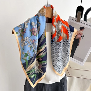 French floral silk square scarf with vibrant botanical print hung over white handbag