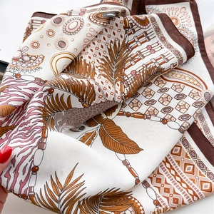 Dettaglio del foulard in seta con stampa leopardata, foglie di palma e bordi marroni
