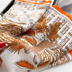 Dettaglio del foulard in seta con stampa leopardo della giungla e bordi arancioni vivaci