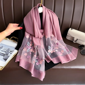 Close-up of pink silk scarf with floral embroidery, pearl beads and diamond patterns