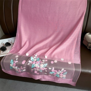 Detail of pink silk scarf with elegant crabapple flower embroidery on leather background