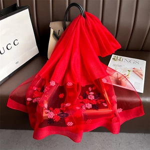 Detailed embroidery of red flowers and sequins on a delicate red chiffon scarf shawl