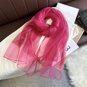 Close-up of lightweight pink silk shawl with a glossy finish on elegant flat lay