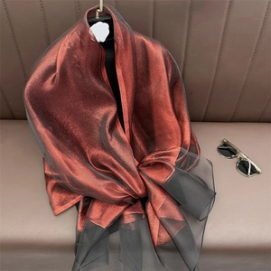 Detail of gradient metallic silk scarf with shimmering translucent fabric and black border