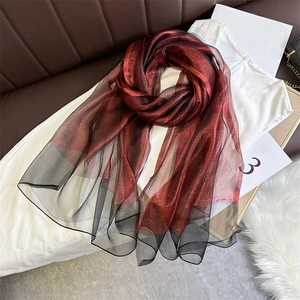Close-up of wine red silk wool scarf with metallic shimmer and black tulle trim