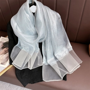 Detail of light blue shimmering silk scarf showing translucent layers and metallic luster