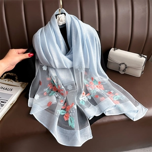 Detail of light blue scarf with 3D floral embroidery and pearls on organza fabric