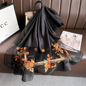 Detail of silk scarf with floral embroidery, elegant black pashmina with bead accents