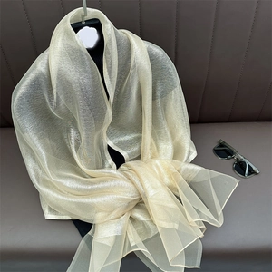 Detail of champagne gold silk shawl with metallic luster on mannequin with sunglasses