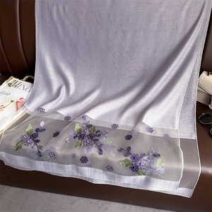 Close-up of light purple silk scarf featuring intricate floral embroidery and mesh detail