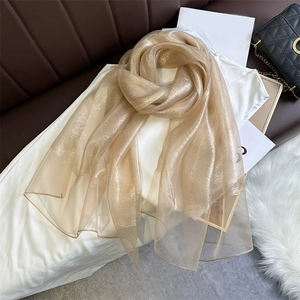 Detailed view of champagne gold shimmering fabric scarf with reflective metallic finish