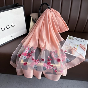 Detail of pink silk scarf featuring 3D floral embroidery and delicate pearl accents