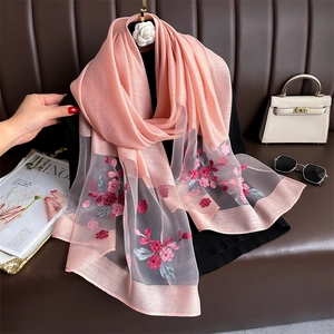 Detail of light pink silk scarf with delicate 3D floral embroidery and beadwork accents