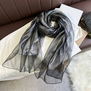 Close-up of the shimmering silver-black metallic fabric of this fashion silk scarf