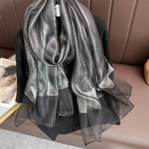 Detail of silver metallic silk scarf with black sheer mesh patchwork and shimmer finish