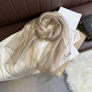 Detailed macro of champagne gold silk shawl with shimmering texture and elegant drape
