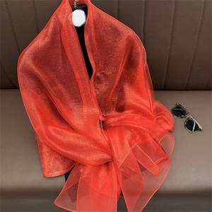 Detail of vibrant red silk-blend shawl showing lightweight texture on a mannequin