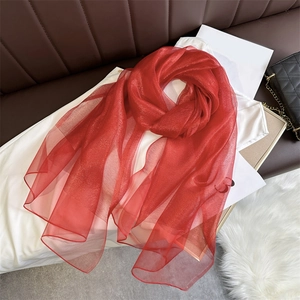 Detail of red sparkling silk shawl with glitter finish and semi-transparent texture