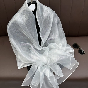 Detailed view of white translucent pearlescent shawl texture on a black mannequin