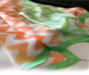 Détail d'un carré de soie avec motifs à vagues chevron en orange et vert tendre
