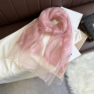 Detail of pink sheer scarf featuring shimmering gold glitter texture and lightweight fabric